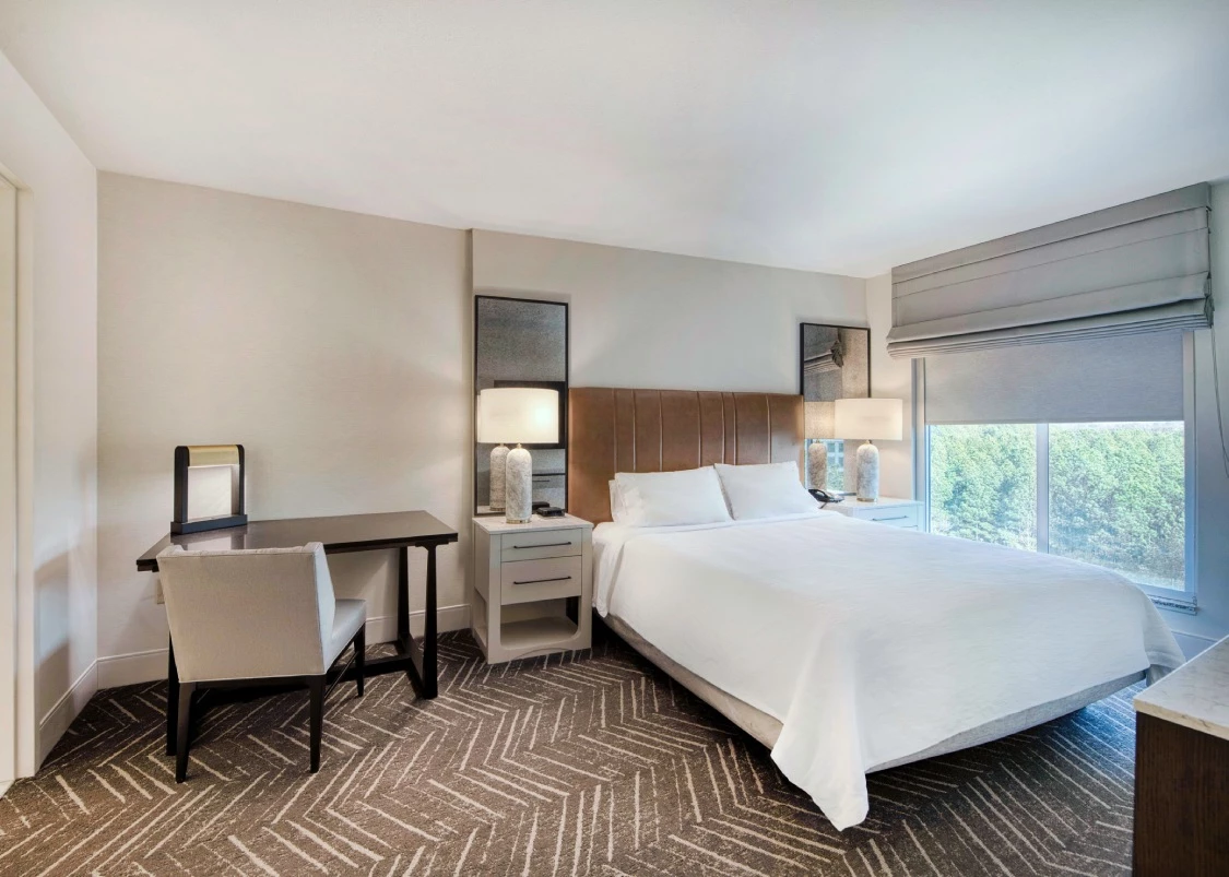 a hotel room with a bed and a desk