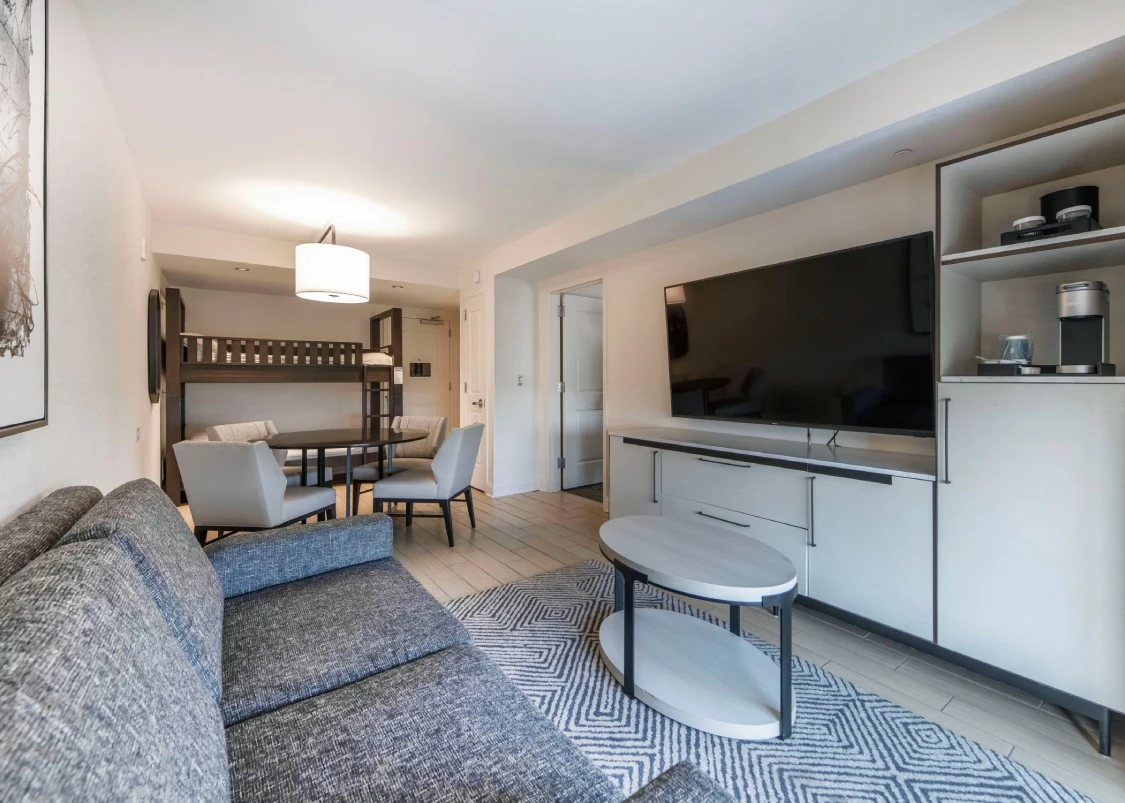 a hotel living room with a couch and a tv