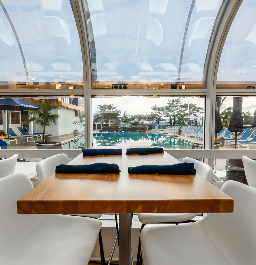 a table with chairs and a pool in the background