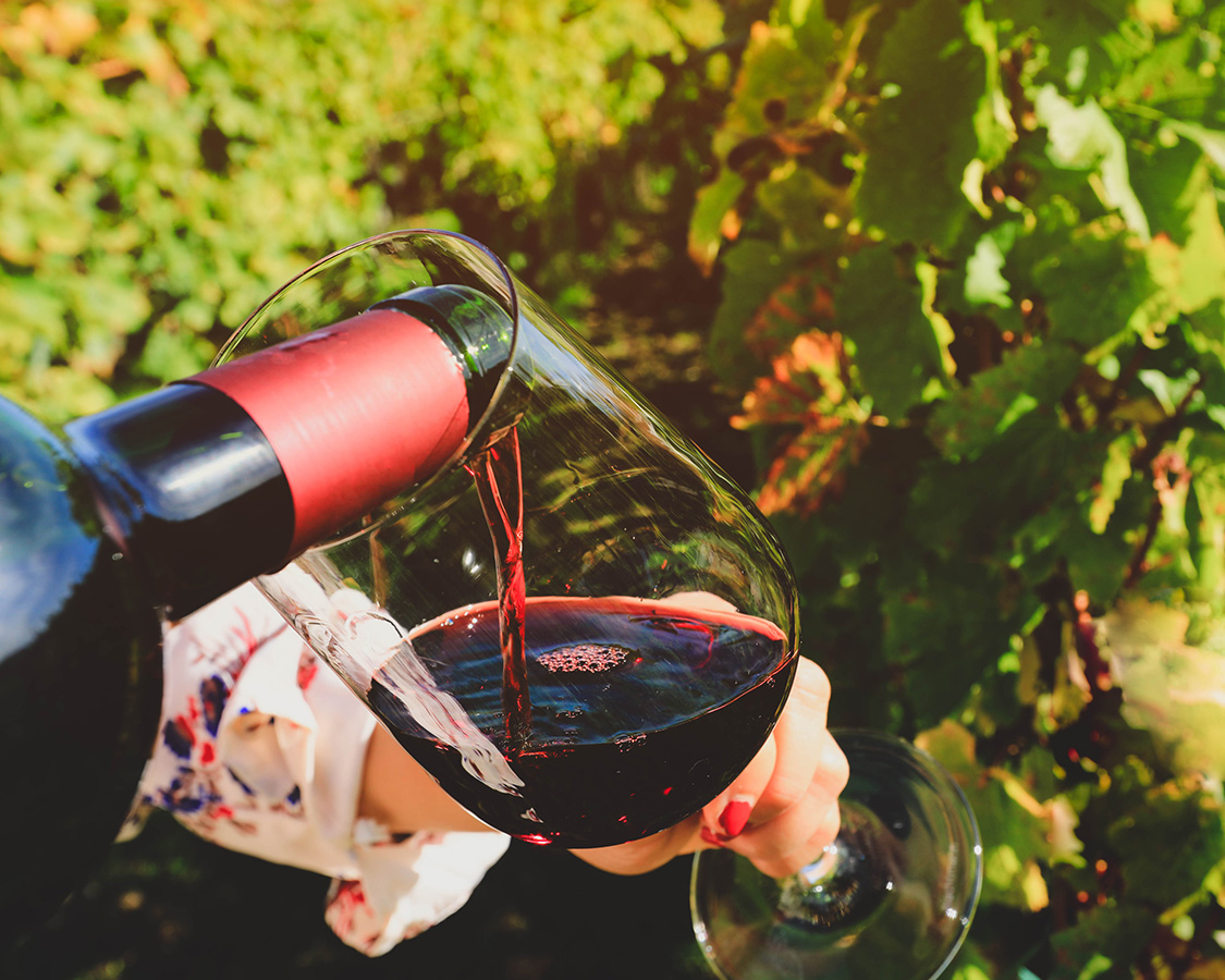 a person pouring wine into a glass