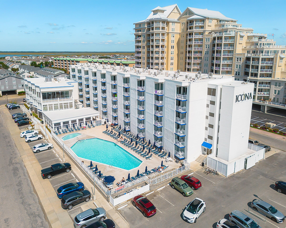 a building with a pool and cars parked in front of it