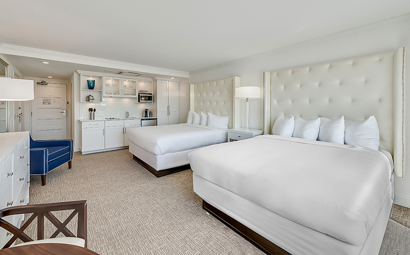 a room with two beds and a kitchen