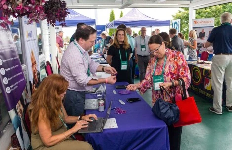 a group of people at a table with laptops