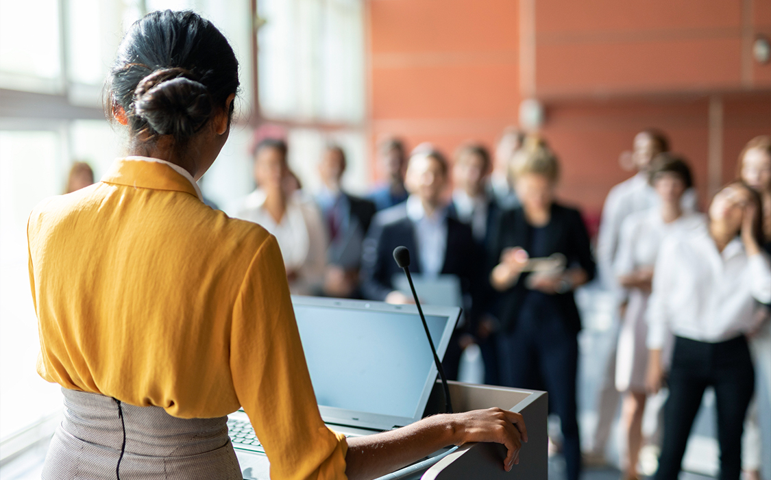 a woman standing at a podium with a microphone