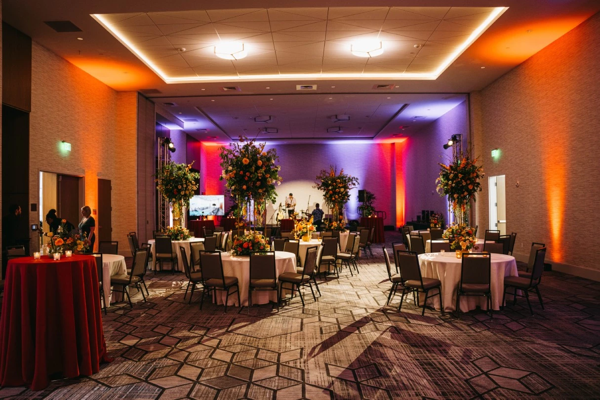 a room with tables and chairs and flowers