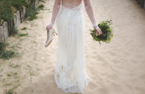 a woman in a white dress holding a bouquet of flowers and shoes