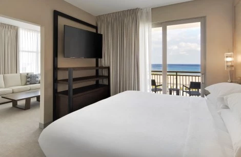 a suite with a television and a view of the ocean