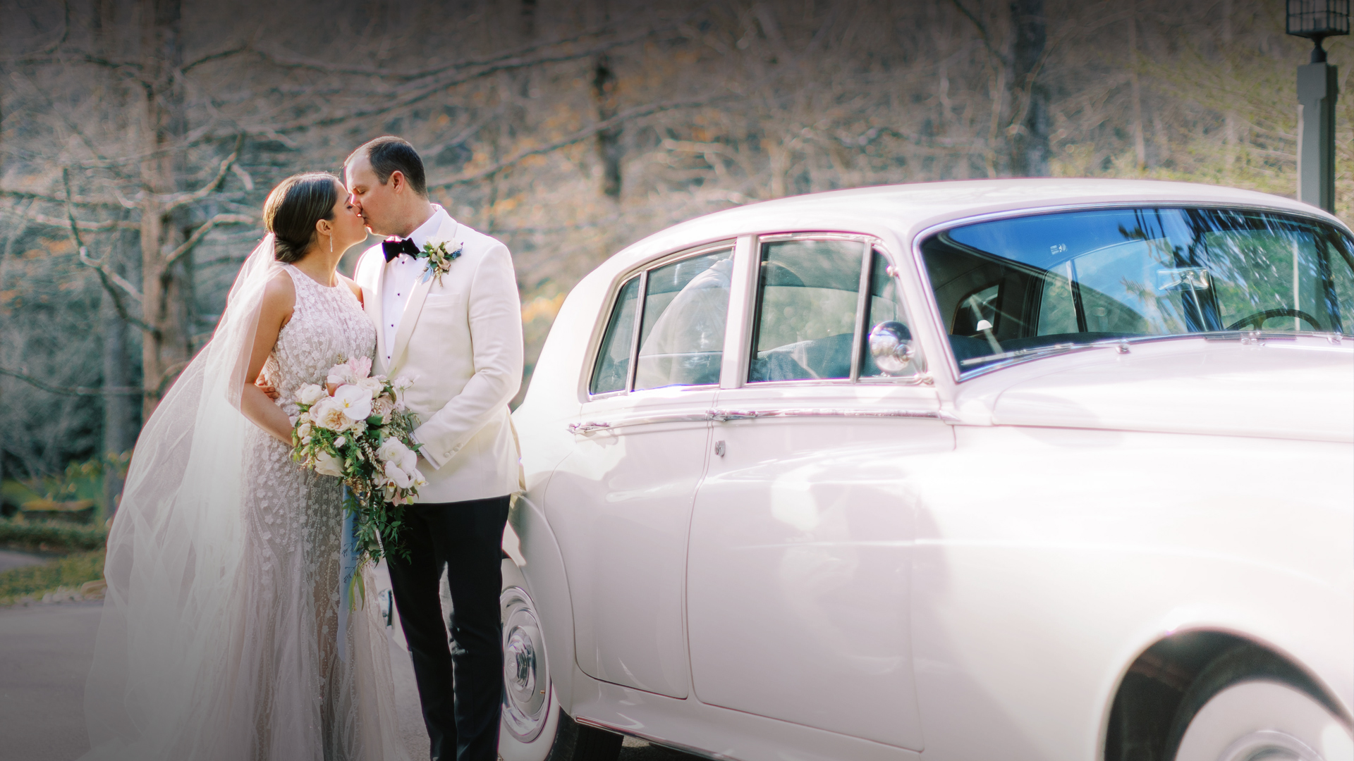 a man and woman kissing next to a car