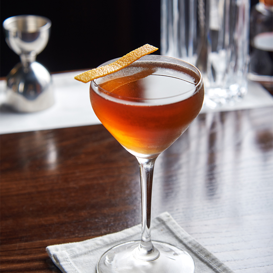 a glass with a drink on a napkin