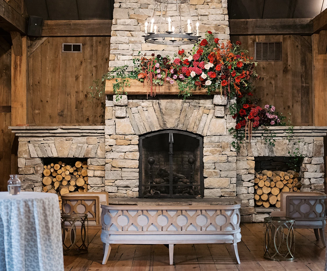 a fireplace with flowers on the mantle