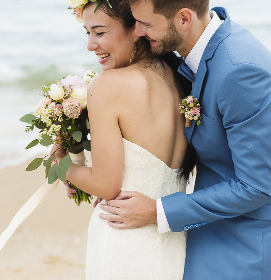 a man and woman hugging on a beach