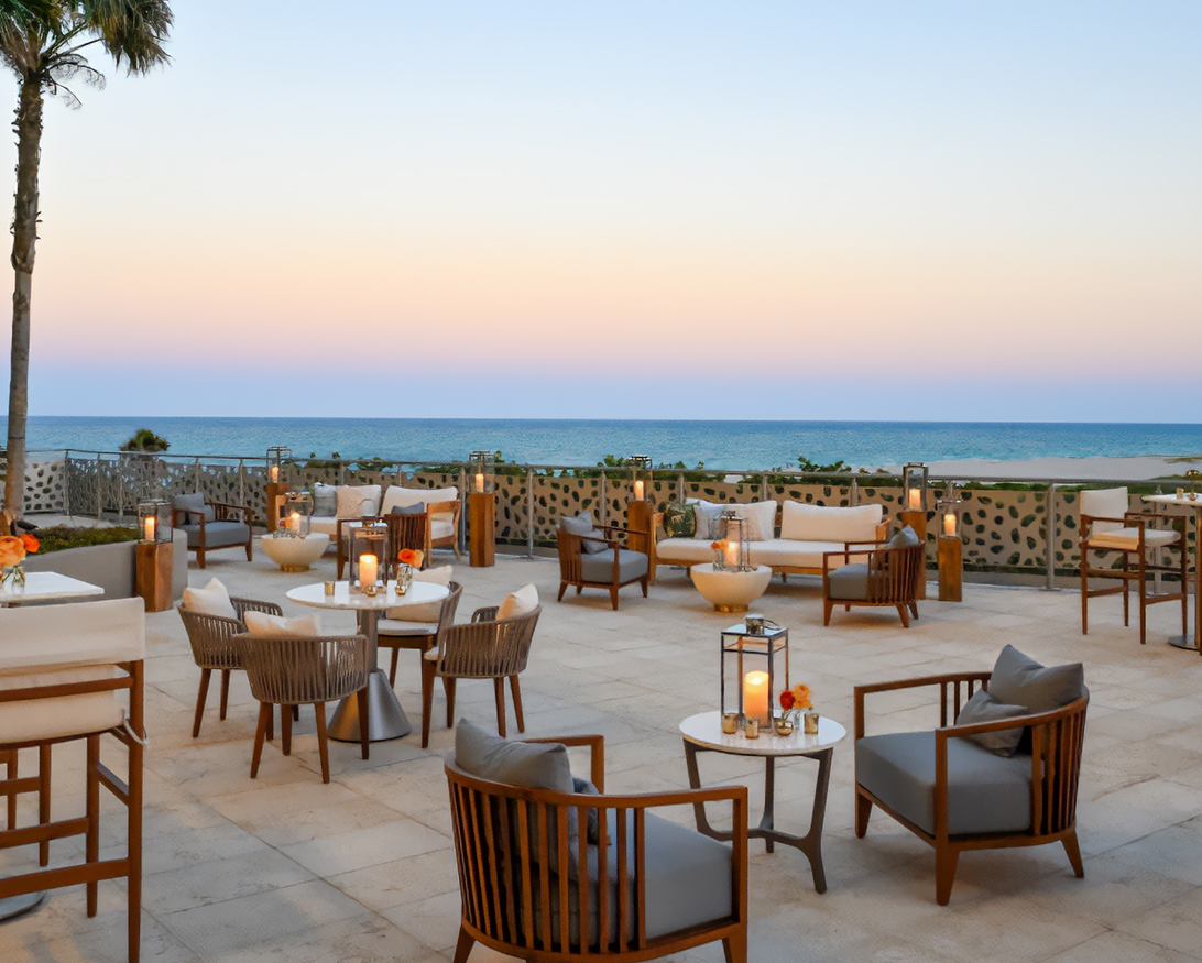 a patio with chairs and tables on a sunny day