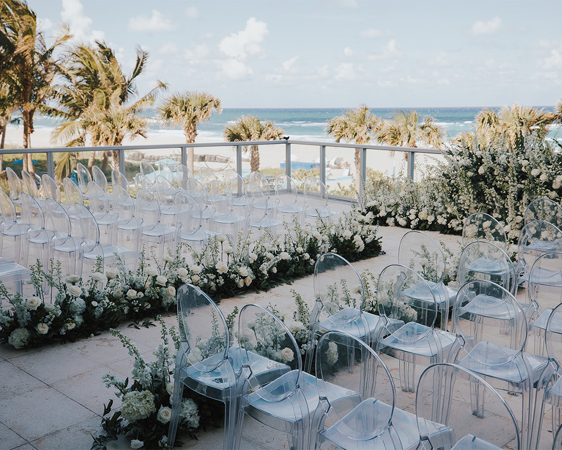 a group of clear chairs with flowers on a patio