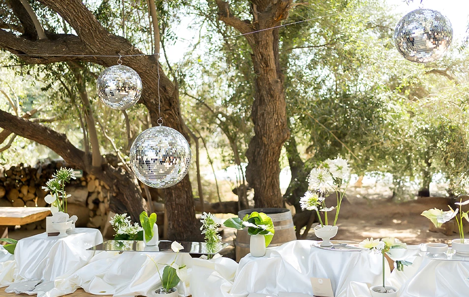 a table with white tablecloths and silver balls from it