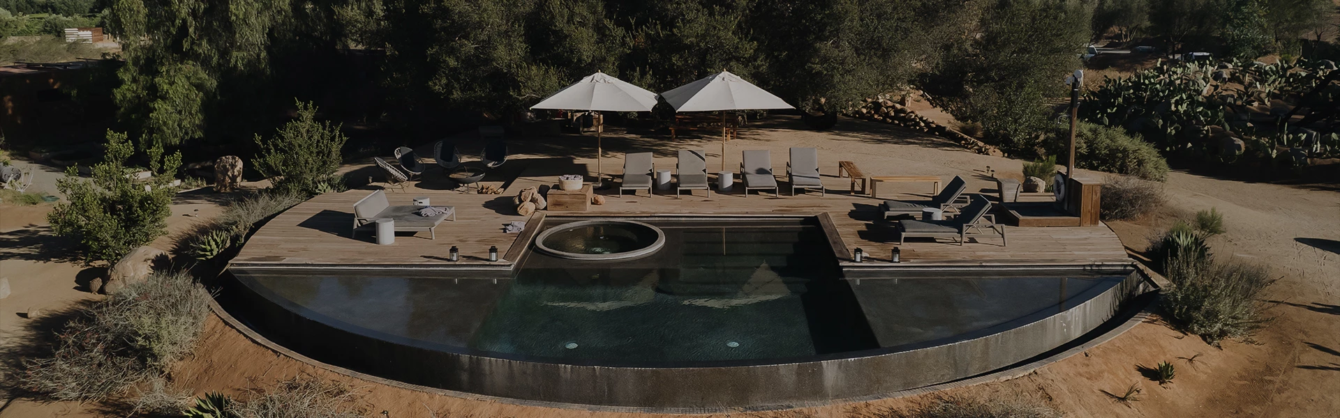 a pool with umbrellas and chairs on a deck
