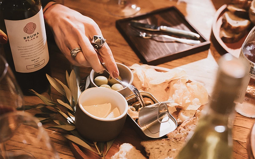 a person's hand holding a spoon over a bowl of food