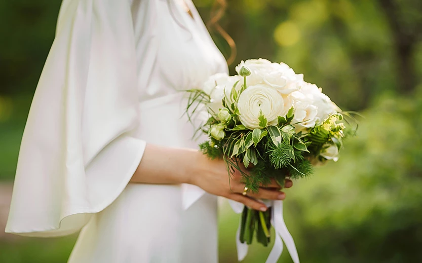 a woman holding a bouquet of white flowers