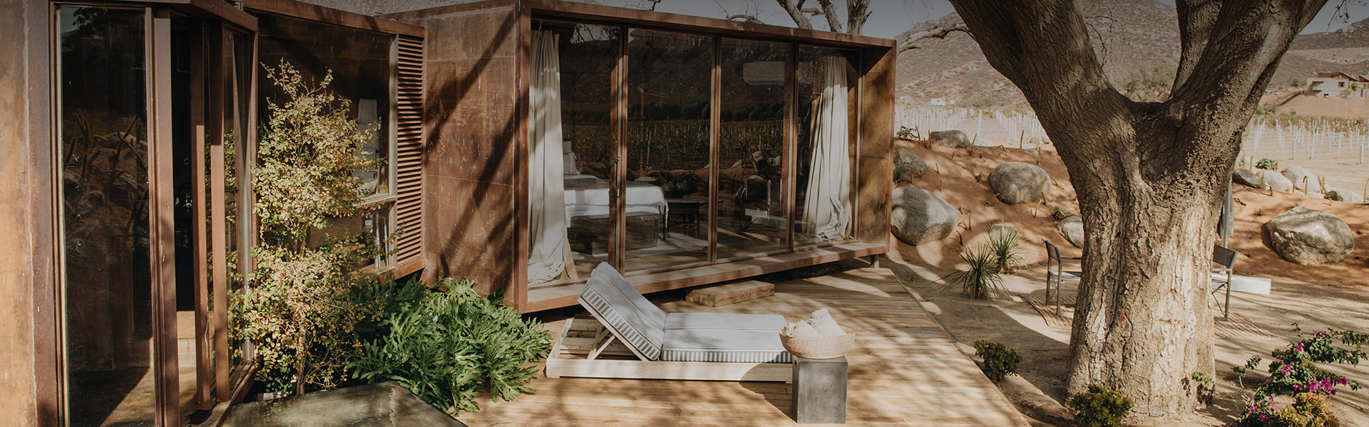 a deck with a bed and a glass wall