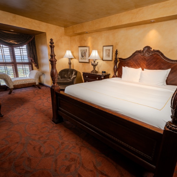 a bedroom with a bed and chairs