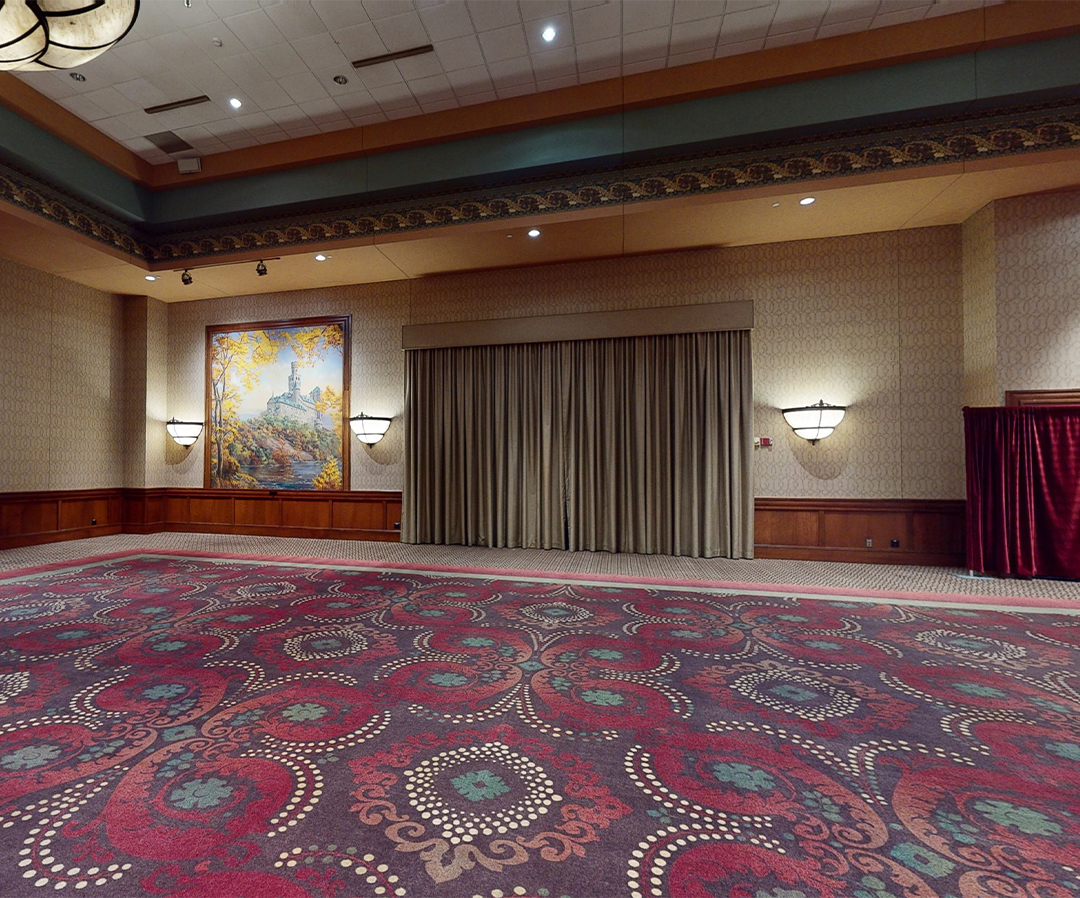 a large room with a large carpet and a painting on the wall