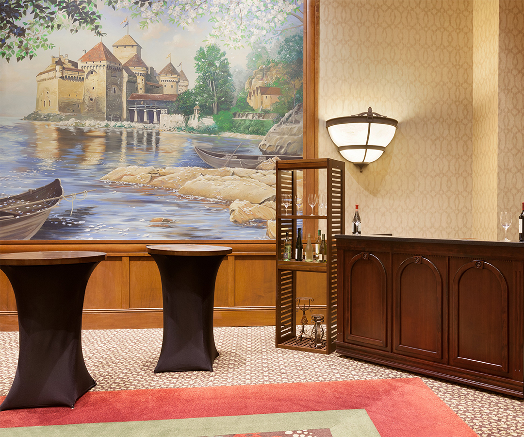 a room with a painting and tables