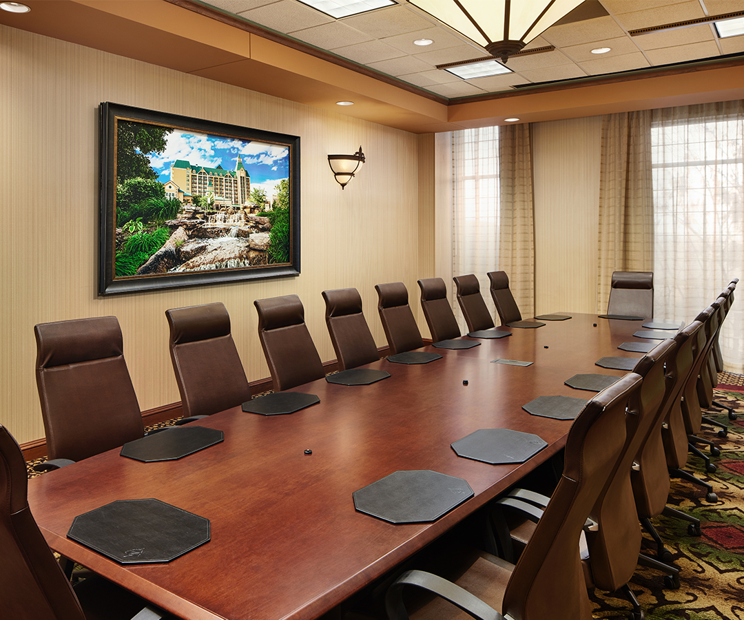 a long conference table with chairs and a picture on the wall