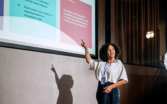 a woman pointing at a projector screen