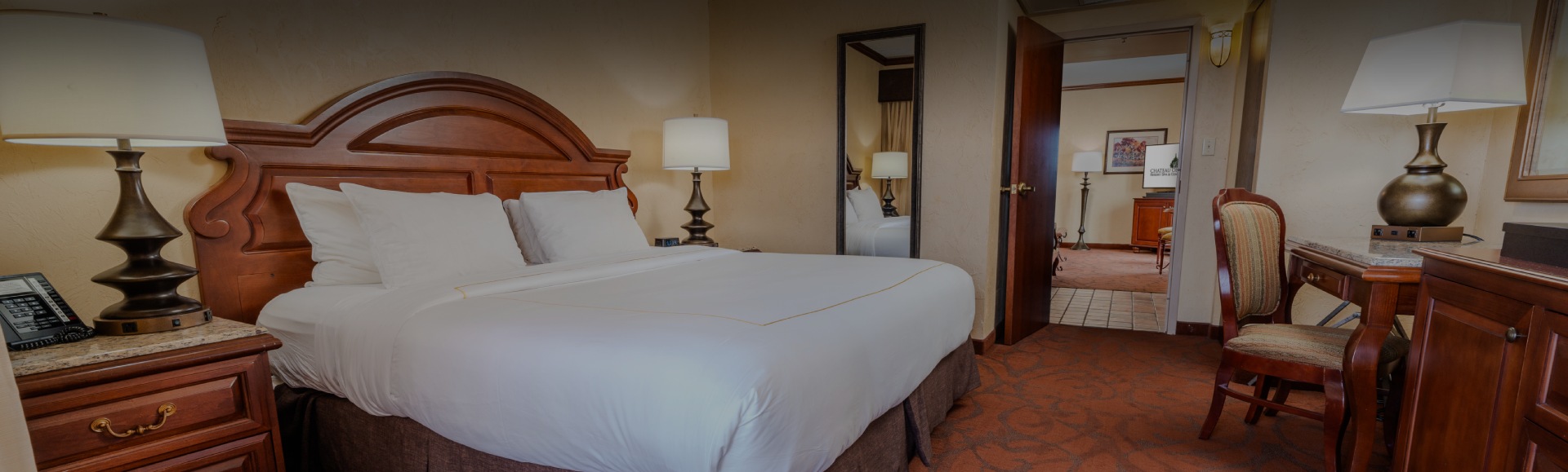 a bed with a lamp next to a mirror