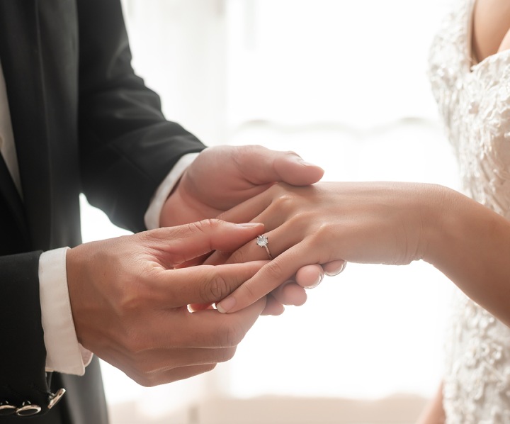 a man putting a ring on a woman's hand