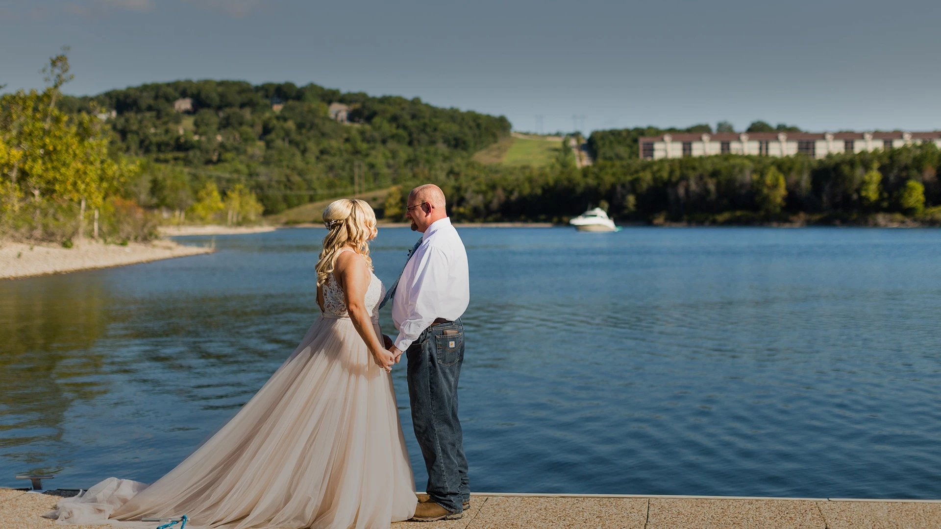 a man and woman standing on a dock by water