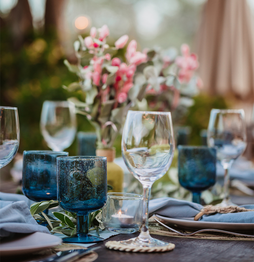 a table set with blue glasses and plates