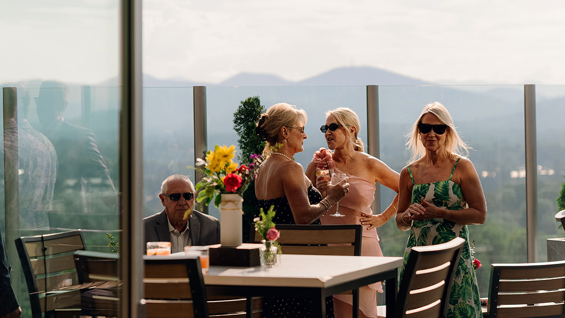 a group of women standing around a table with drinks