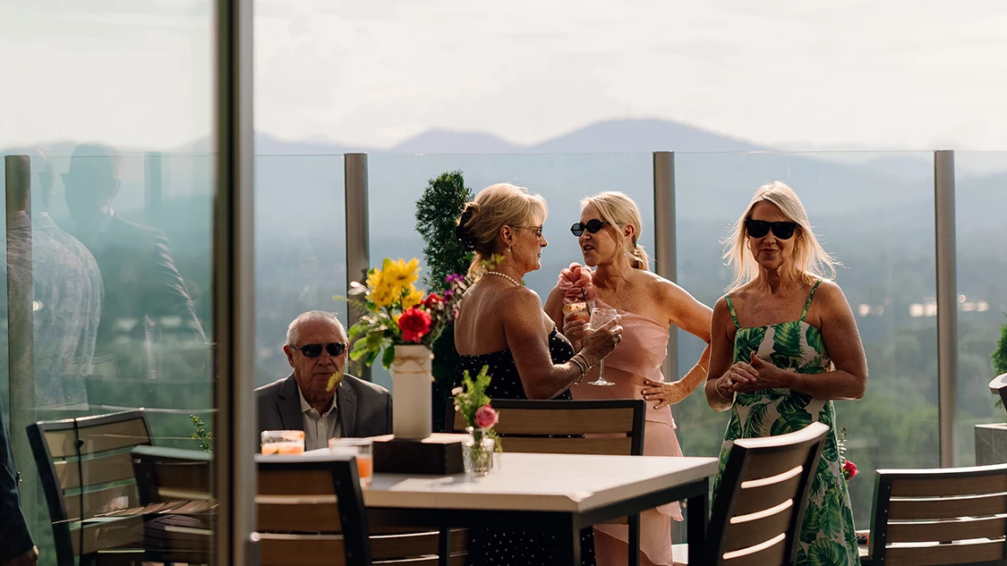 a group of women standing around a table with drinks