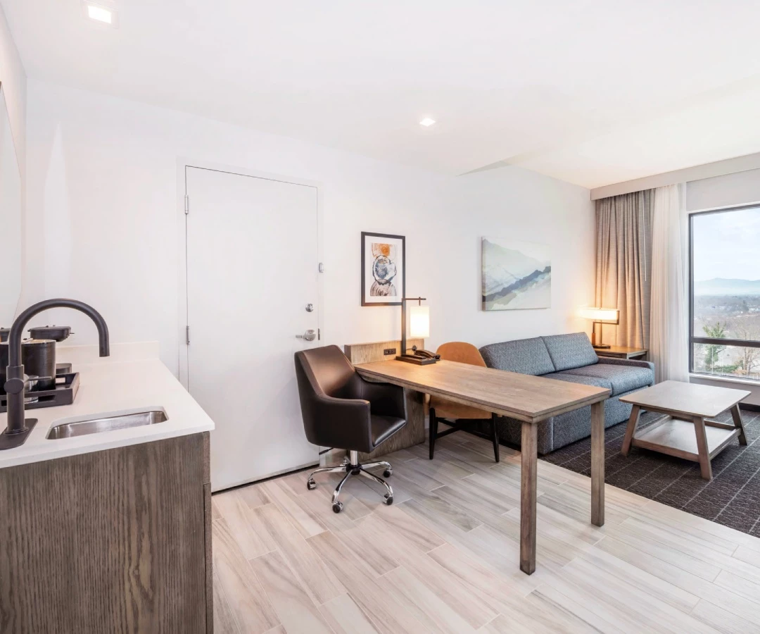 a room with a desk and chairs