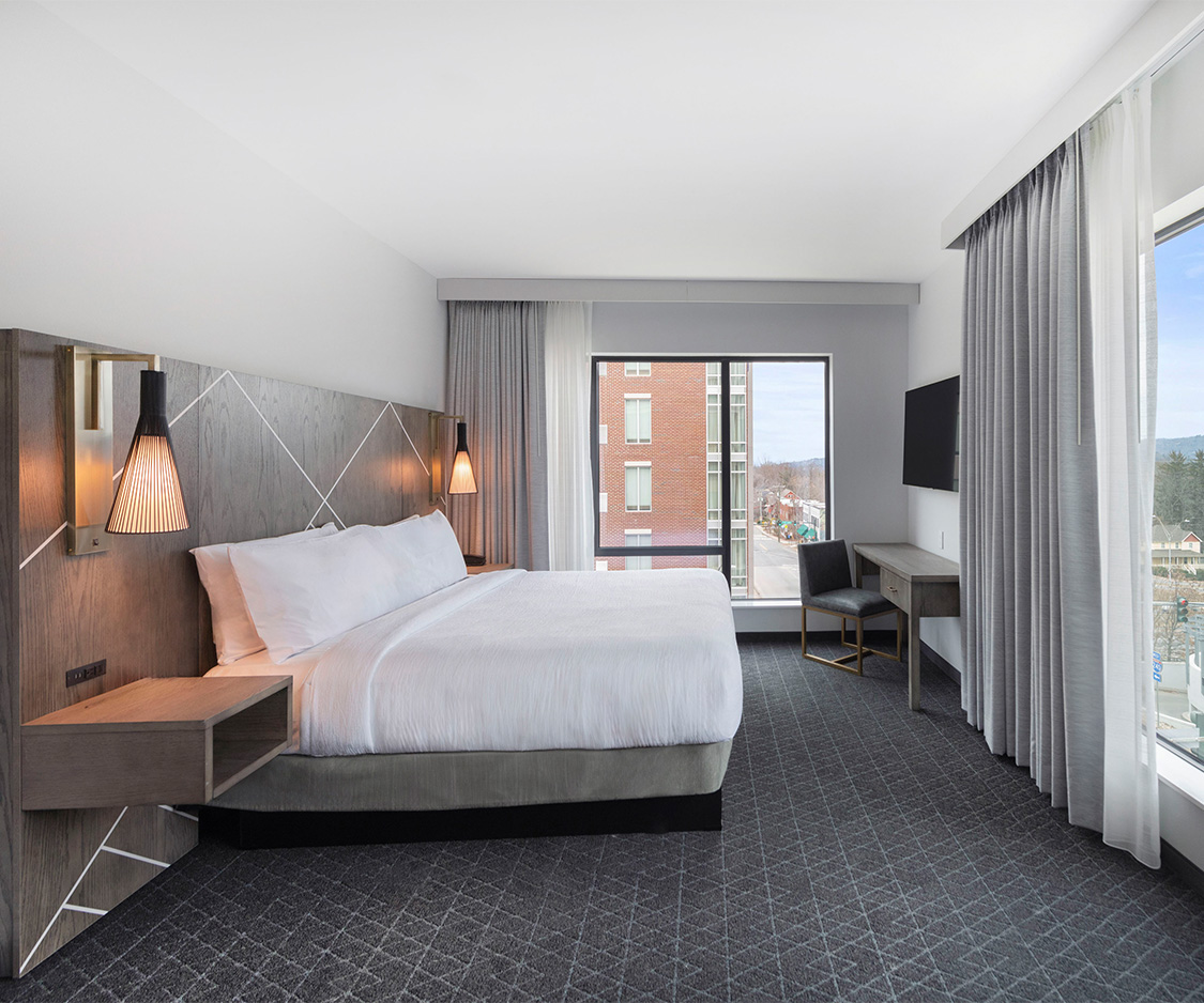 a hotel room with a bed and a television
