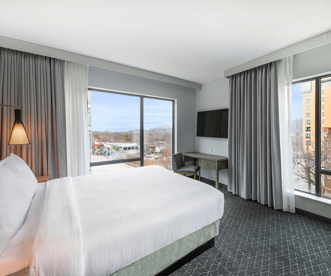a bedroom with a large bed and a desk