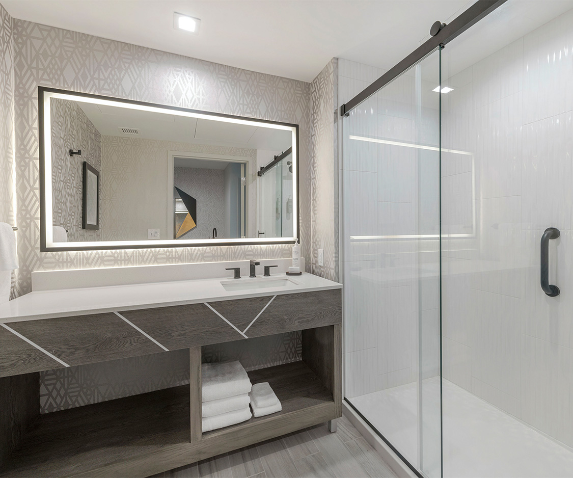 a bathroom with a glass shower and a sink