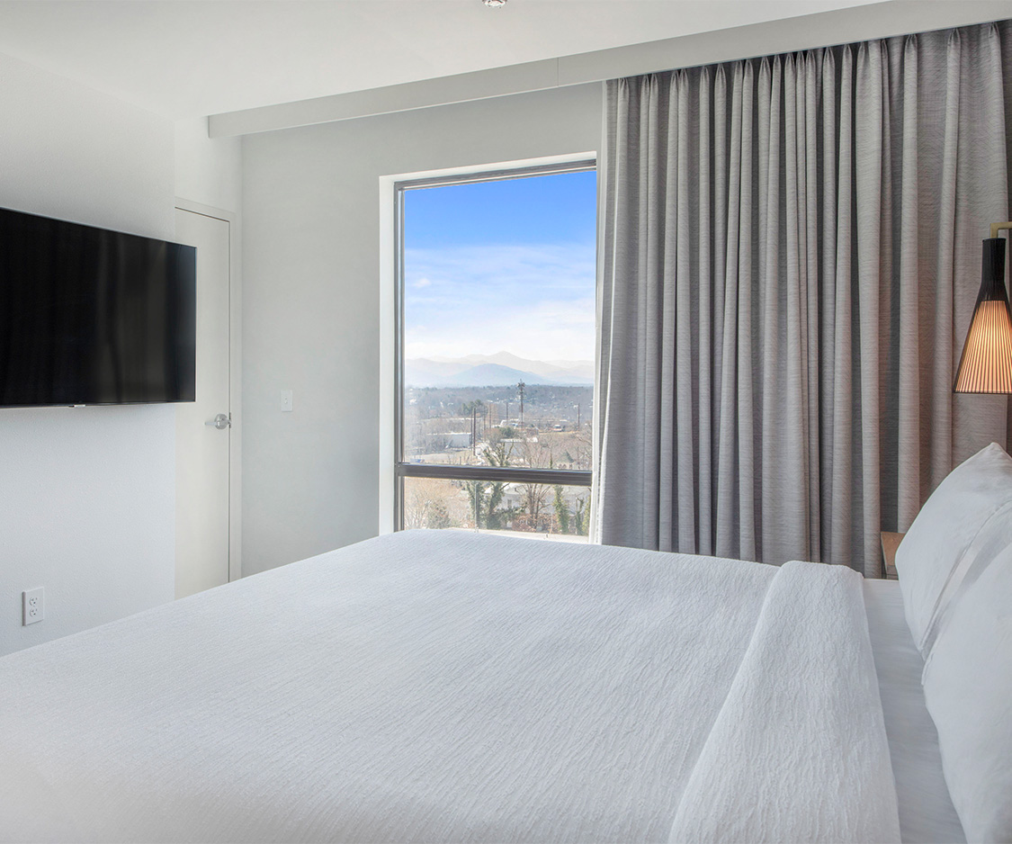 a bed with a television in the window