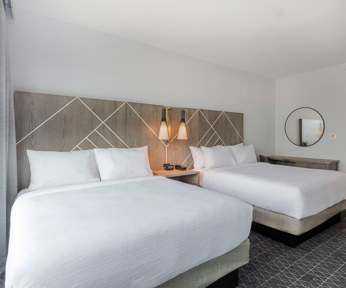 a room with two beds and a mirror