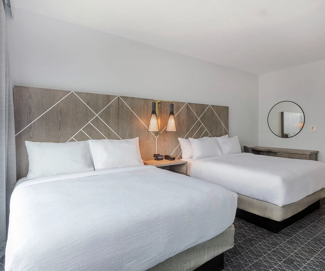 a room with two beds and a mirror