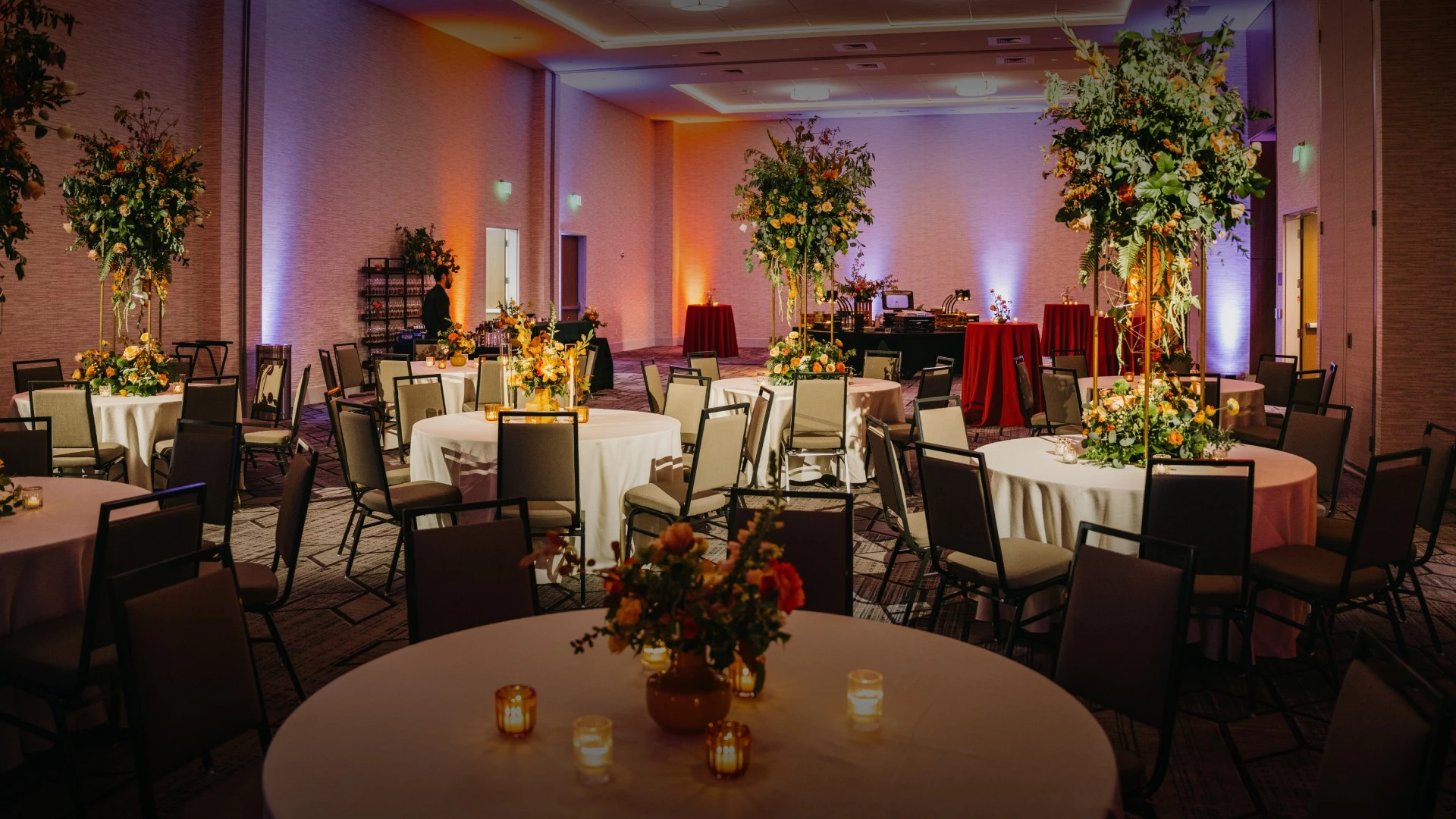 a room with tables and chairs and flowers