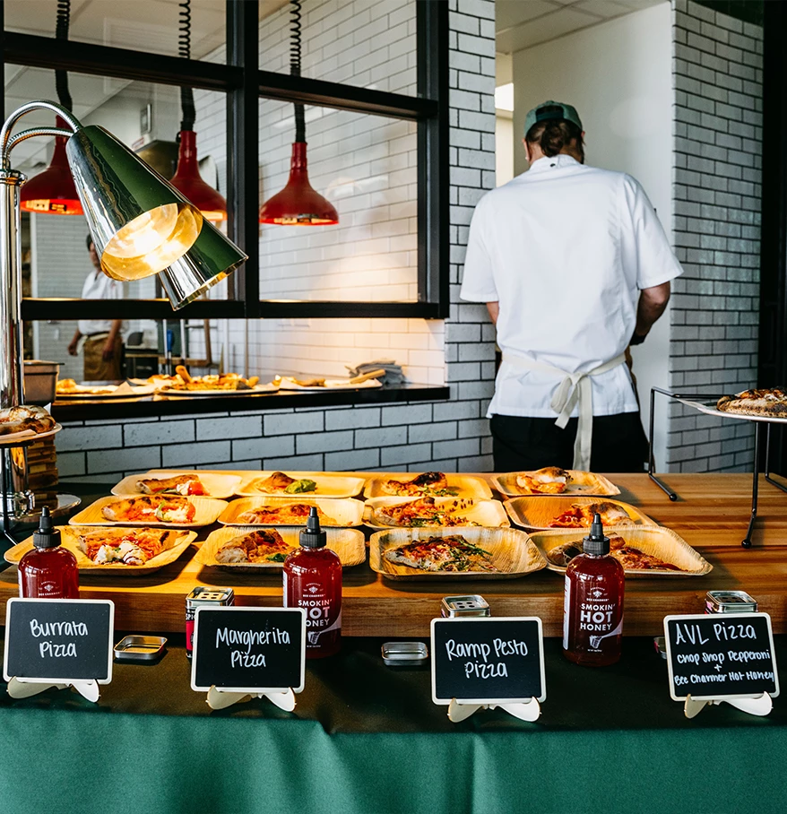 a man standing behind a table with food on it