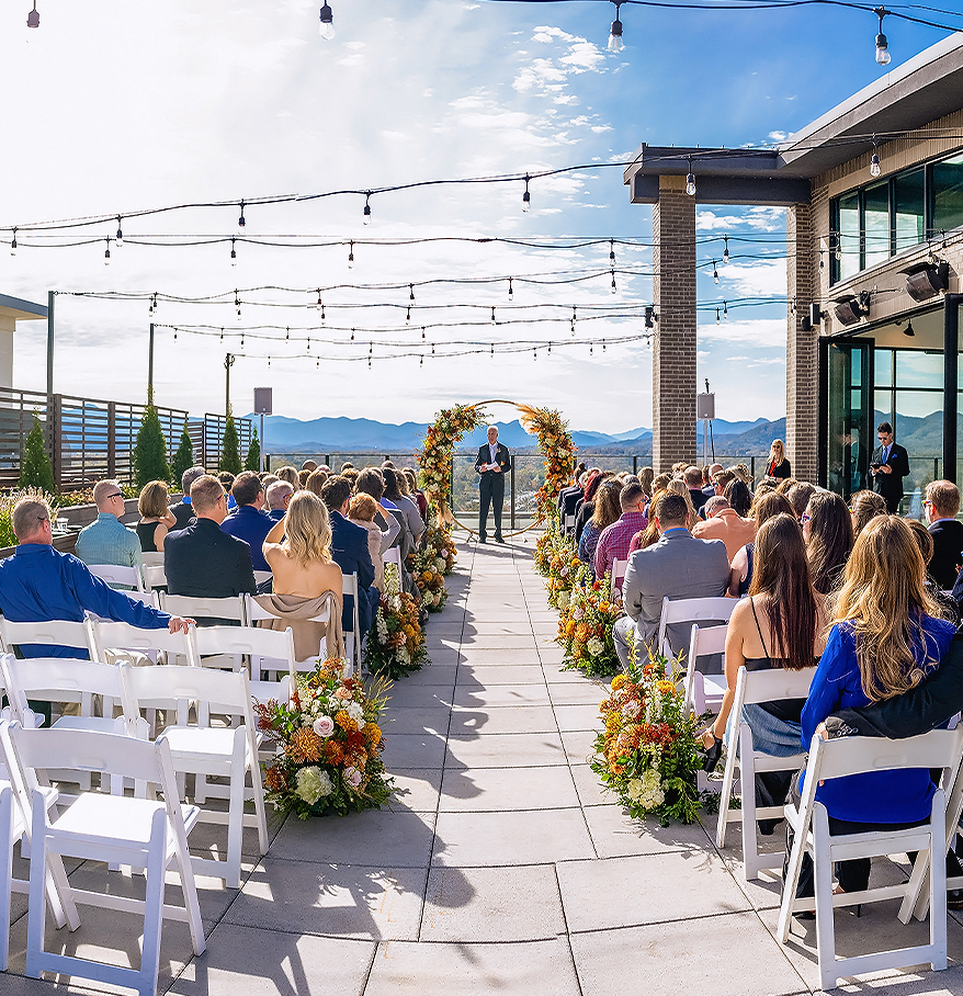 a group of people sitting in chairs at a wedding ceremony