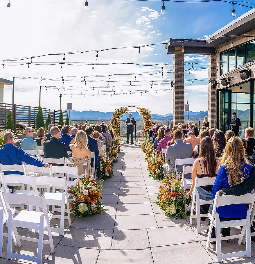 a group of people sitting in chairs at a wedding ceremony