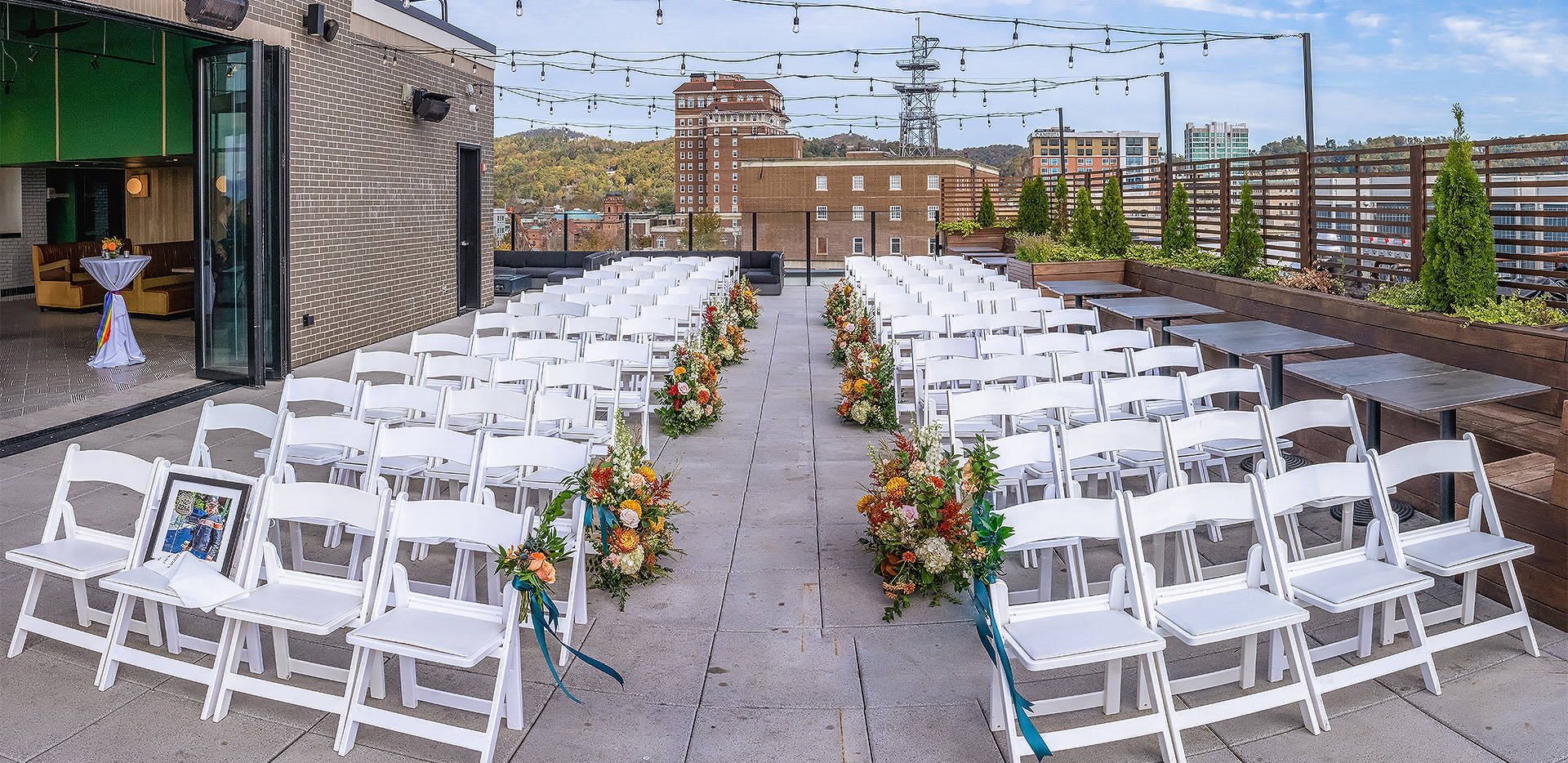 a group of white chairs with flowers on the side