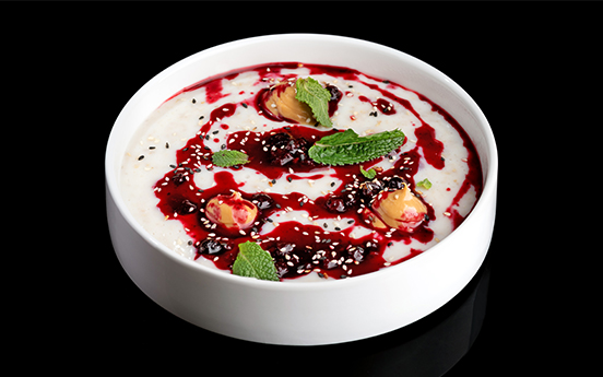 a bowl of food with red sauce and mint leaves