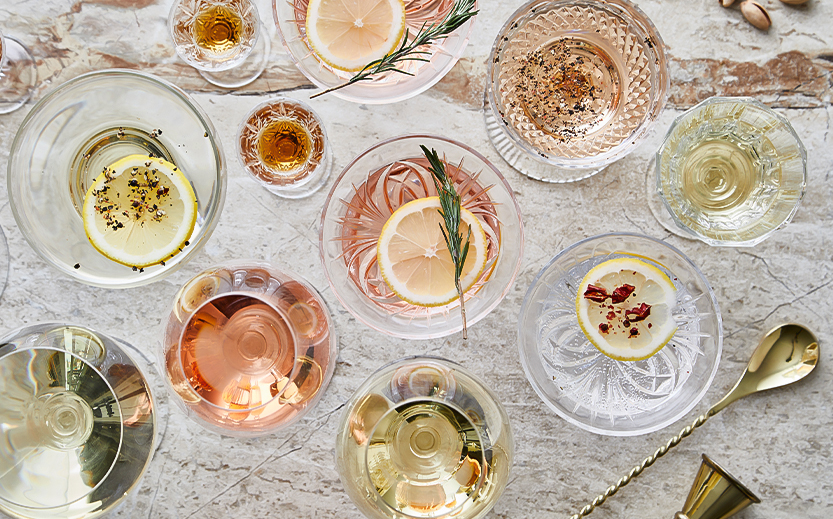 a group of glasses with different colored drinks