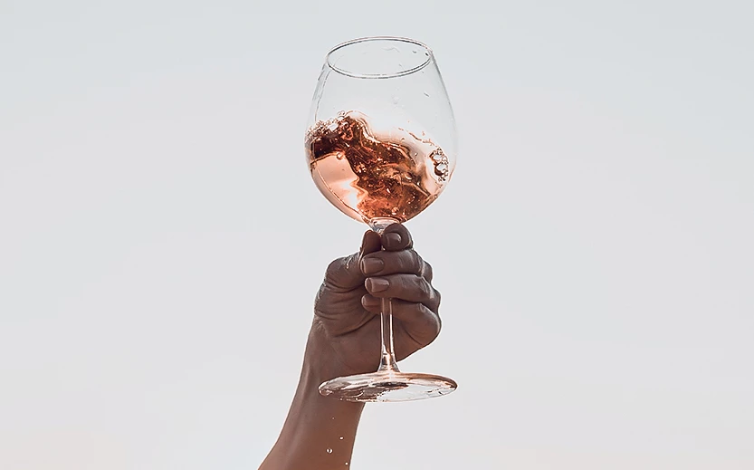 a hand holding a glass of wine