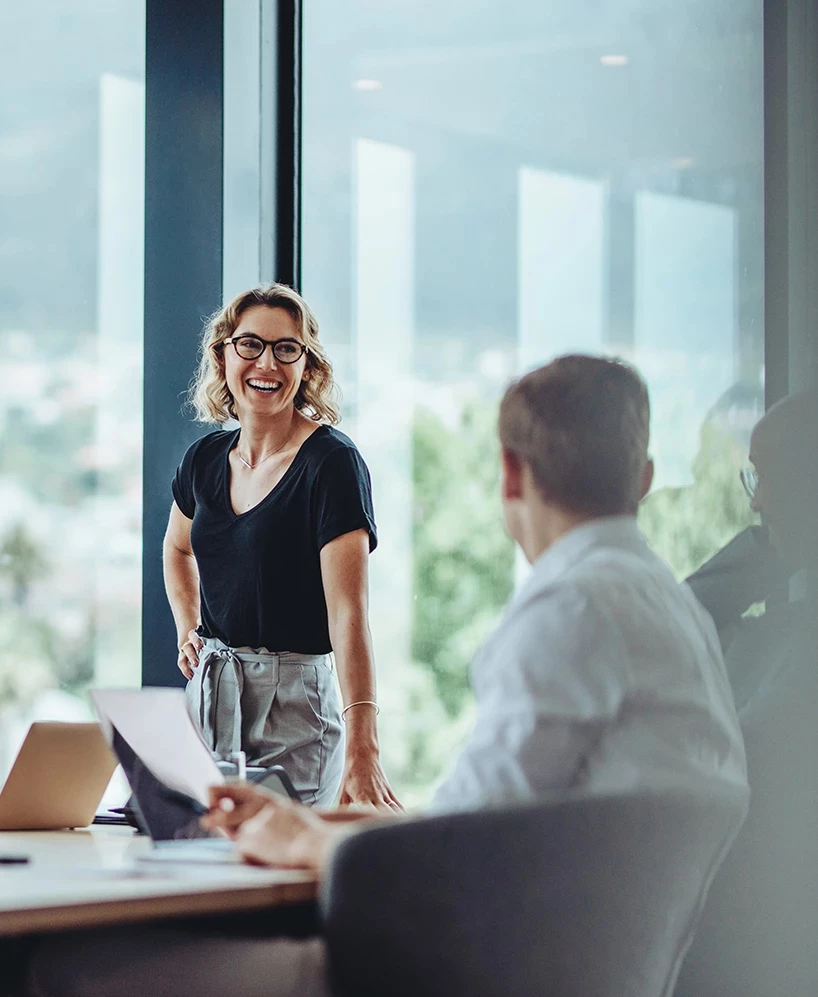 a woman standing in front of a man sitting at a desk