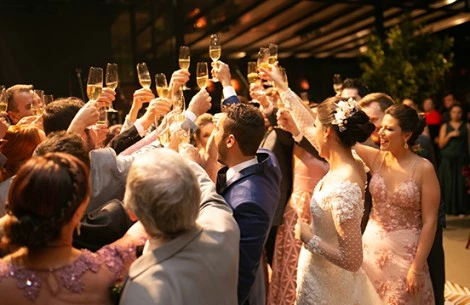 a group of people holding up glasses cheering the bride and groom